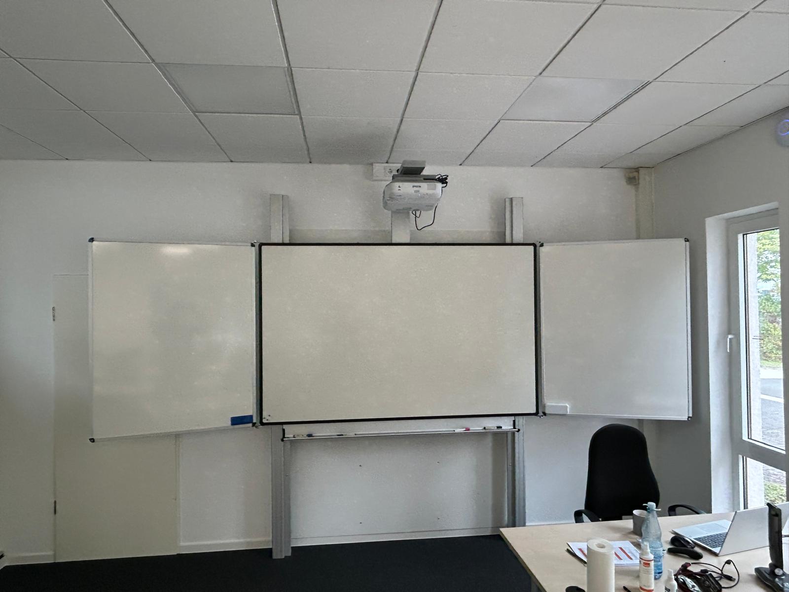 Große Whiteboard-Klapptafel mit Projektionsfläche und Seitenflügeln im Unterrichtsraum