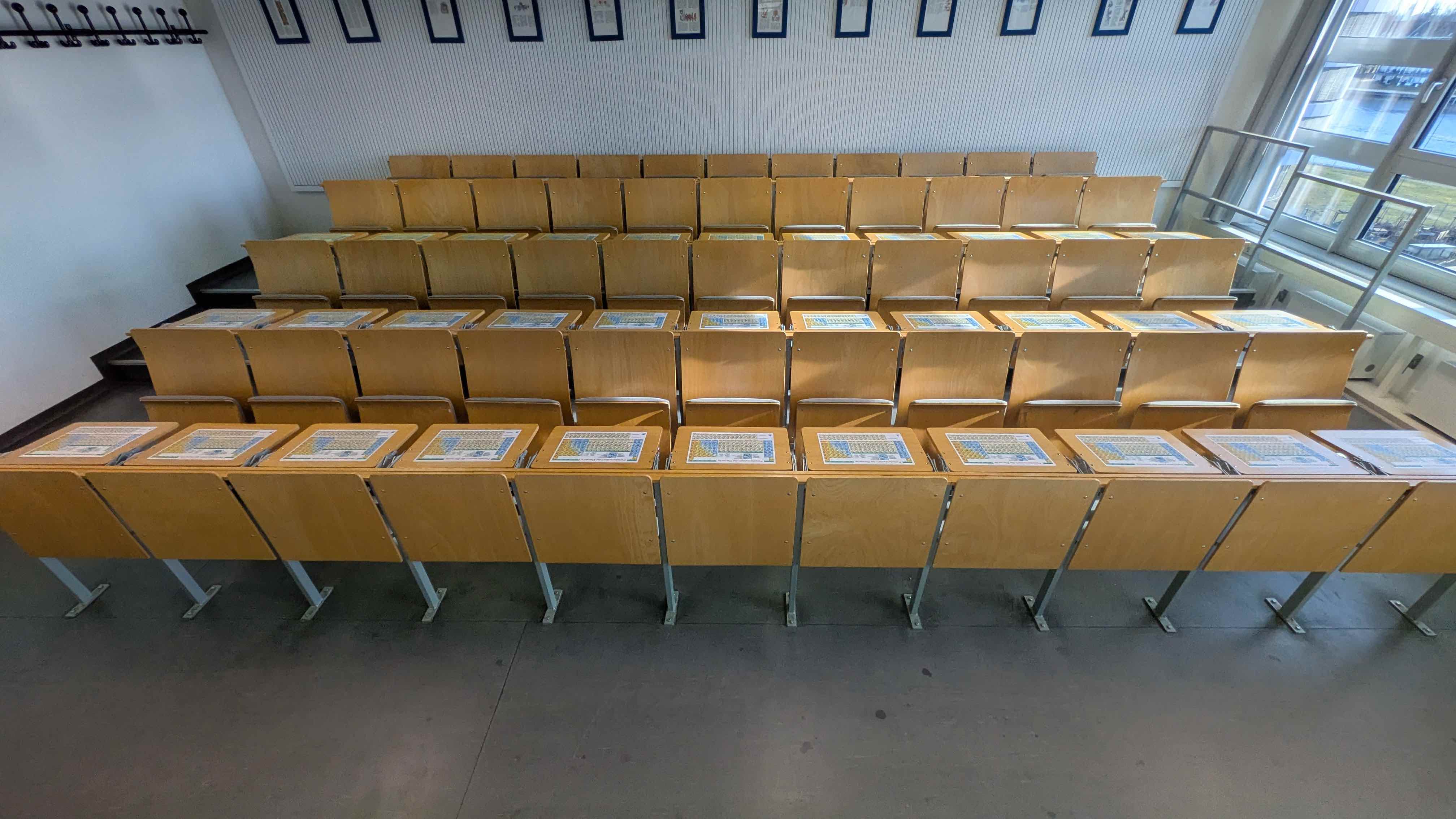 Blick auf die Sitzreihen eines Chemie-Hörsaals mit selbstklebenden blume Periodensystem-Tischsets auf den Arbeitsflächen