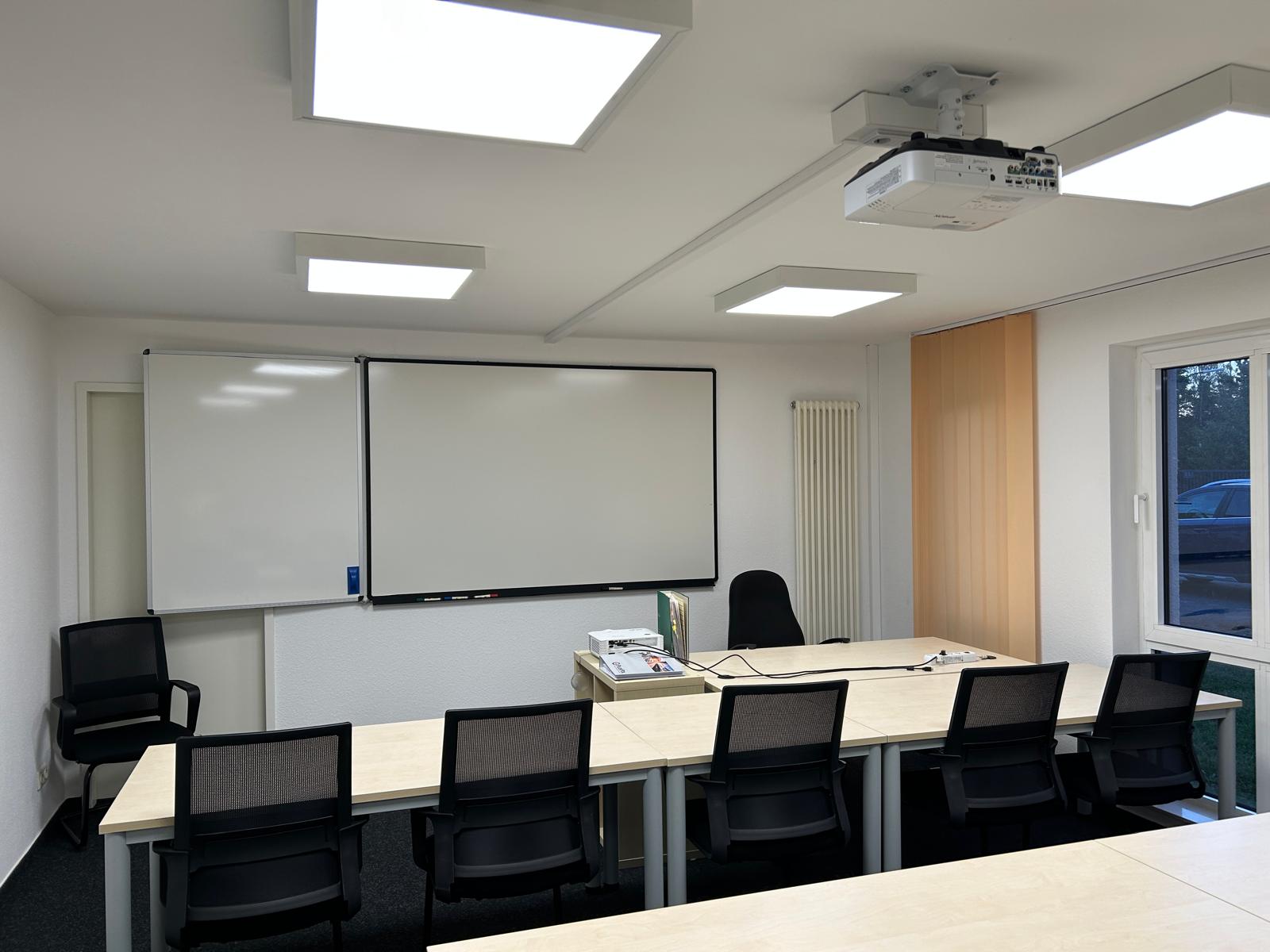 Individuelles Tafelsystem mit Whiteboard, Seitenflügel und Beamer in einem Unterrichtsraum